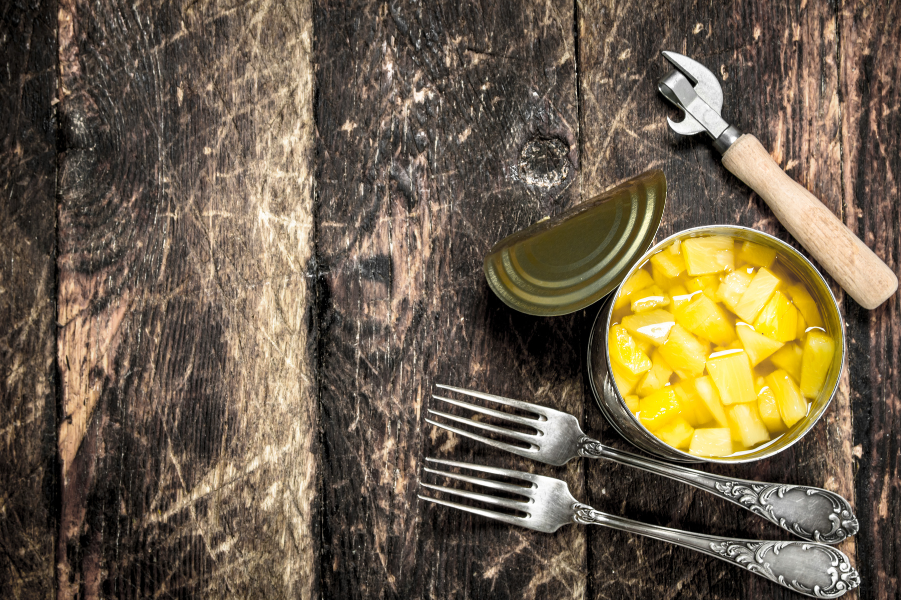 Canned Pineapple in a Tin Can with Forks and Opener.